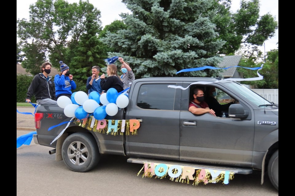 Teachers wish the Class of 2021 well in the parade.