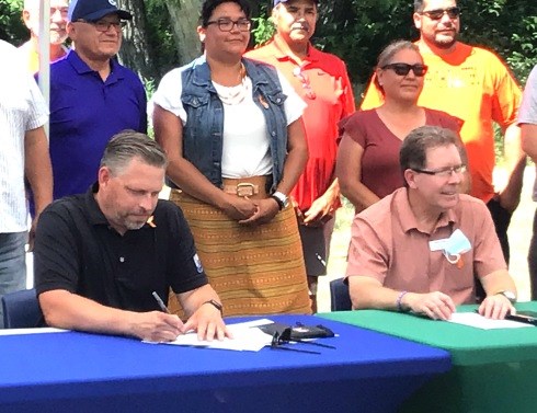 Battleford mayor Ames Leslie and North Battleford mayor David Gillan sign the documents to join the Coalition of Inclusive Municipalities.