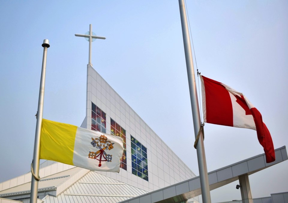 The flags of the Vatican, left, and Canada at the Roman Catholic Cathedral of the Holy Family