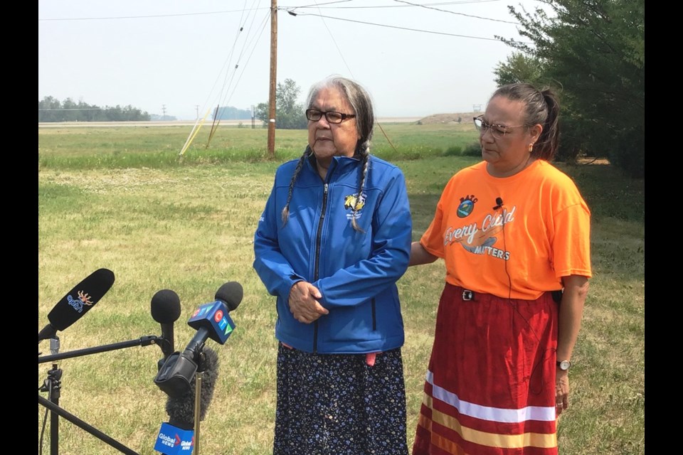 Senator Jenny Spyglass speaks, with Karen Whitecalf, Saturday at the former site of the Delmas residential school. Spyglass attended the school and her brother died while attending.