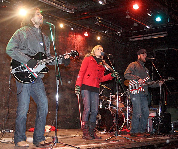 Musicians perform Christmas songs from the stage car of the CPR's Holiday Train, which rolled into Weyburn on Friday evening alongside Railway Avenue. The musicians include Juno-award winning singer Melanie Doane, centre, and singer-songwriter Adam Puddington on bass at right. The CPR employees gave a donation of $2,000 to the Salvation Army, and members of the public who attended the event also brought bags of food collected by the Salvation Army's van.