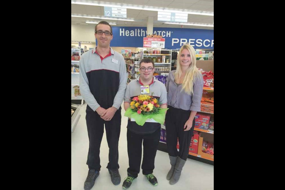 From left: Brendon Lobraico, Store Manager, Shoppers Drug Mart; Neil den Brok and Brittany Garbutt, Employment Specialist, Partners in Employment. Floral arrangements kindly donated by All About Flowers.