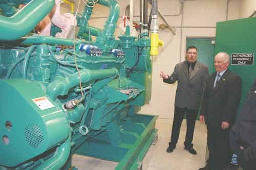 Buchholzer and City Councillor Bob Maloney beside the plant's back-up power generator.