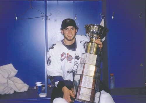 Stoll poses for a photo with the first (WHL) of two trophies he won as captain of the Kootenay Ice in the 2001-02 season. His Ice later won the Memorial Cup.