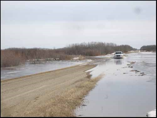 A truck moves over a flood section of grid road