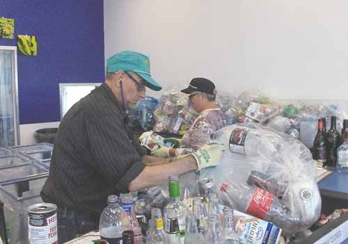 Don Blazeiko, 11-year employee and Wanda Wiome, 3-year employee, sort through a customers recycling.