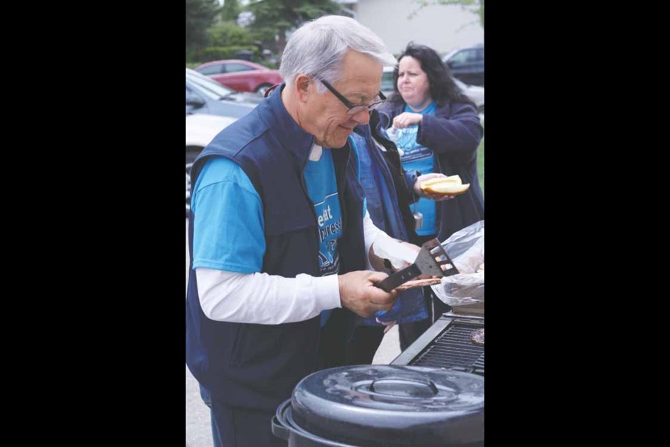Amil Minken flips burgers during the pre-walk barbecue.