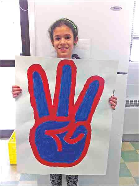 St. Vital School student Marola, holding a large version of the We Day symbol with fingers making a 'w' for 'we' at the We Day event in Saskatoon Feb. 27. Photo submitted