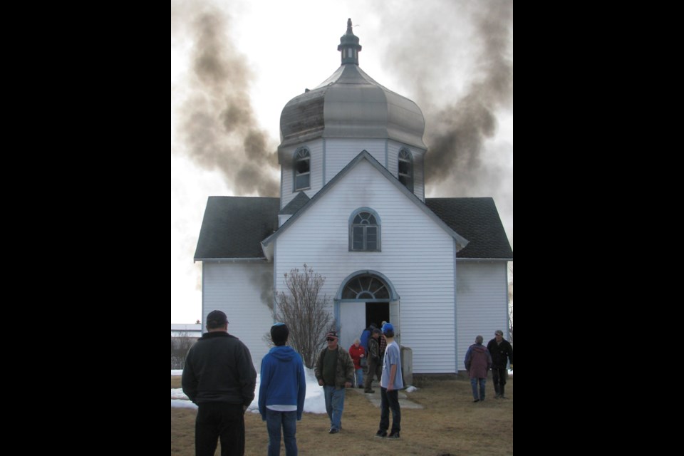 The fire begins to take hold and smoke appears at the dome's windows, which were broken out in advance.