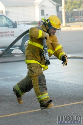 Firefighter Darcy Skarra with the Humboldt Fire Department grabs the hose and takes off running in a practice run.