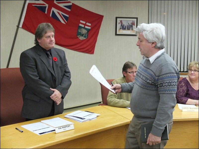 Cal Huntley (left) is sworn in as Flin Flon mayor by Chief Administrative Officer Mark Kolt. Also pictured is Coun. Bill Hanson