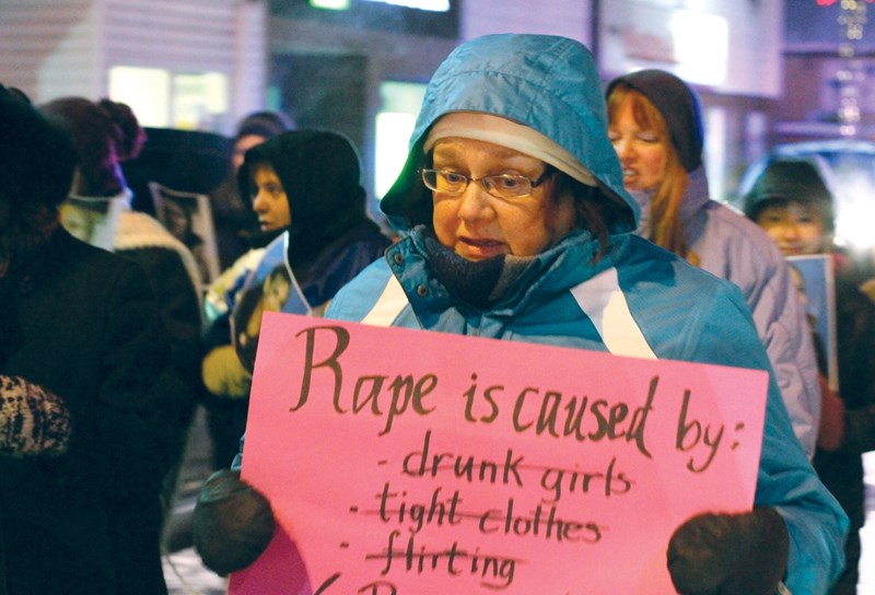 Sheena Reed, board chair of the Women’s Resource Centre, carries a sign in Tuesday’s Take Back the Night March down Main Street.