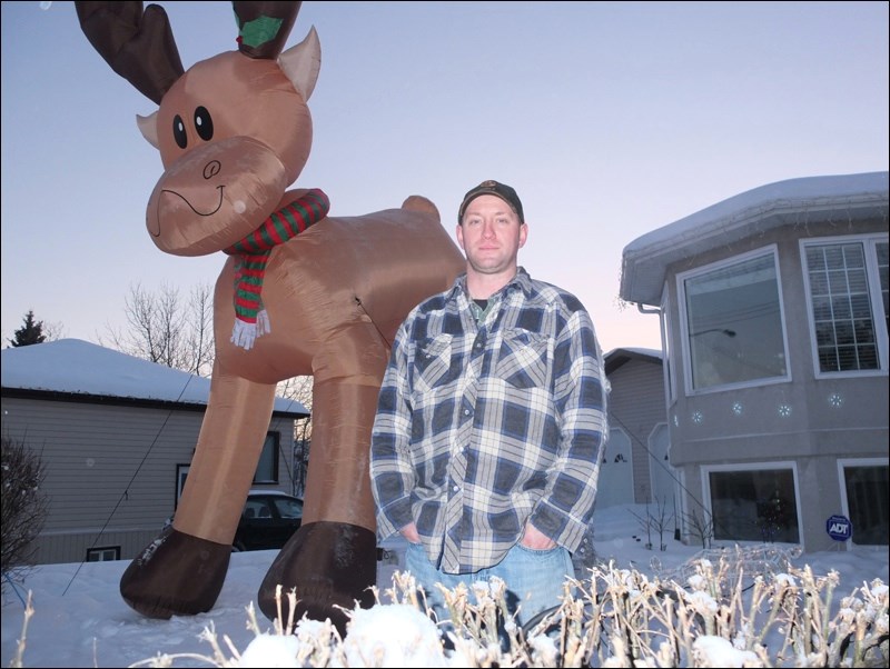 Shane Bentley stands in front of the 16-ft inflatable reindeer in his South Hudson Street yard. Bentley bought the towering ornament off eBay to help bring Christmas cheer to the community. Based on the response so far, he’s succeeded!