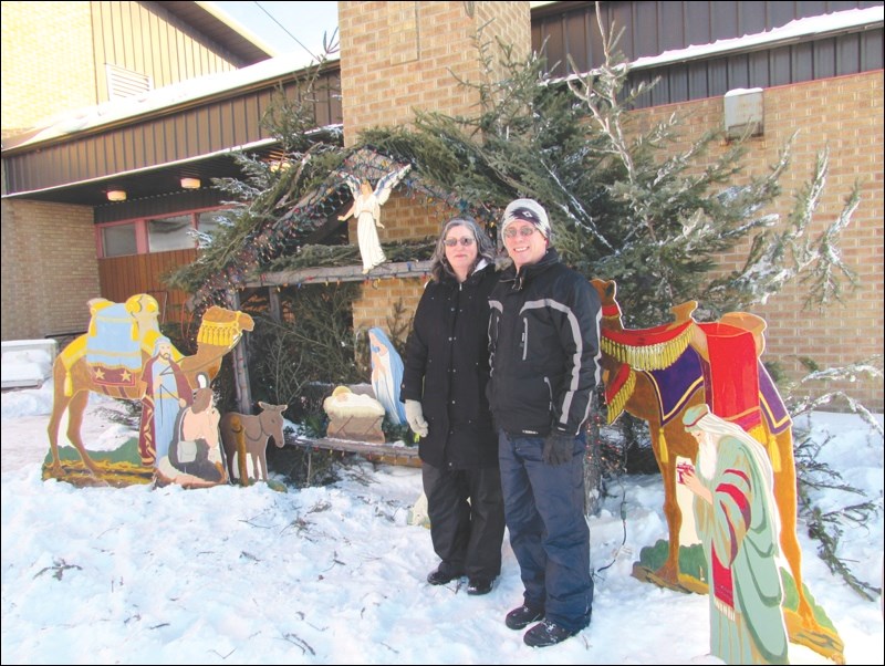 Monica and Richard Kozar of St. Ann’s Roman Catholic Church stand with the church’s Nativity display. Christmas is now just eight days away.