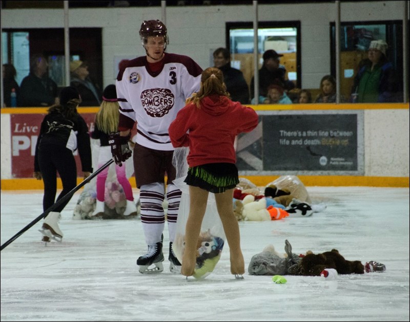 Northland Ford, the Flin Flon Bombers and the community joined efforts earlier this month to collect toys and teddy bears for three local Christmas gift programs. Northland Ford donated 411 presents to the gift programs through the Elks Club, Salvation Army and Flin Flon Aboriginal Friendship Centre. Pictured above, Flin Flon Bomber Tyler Bell helped a member of the Flin Flon Skating Club pack the teddies into bags.