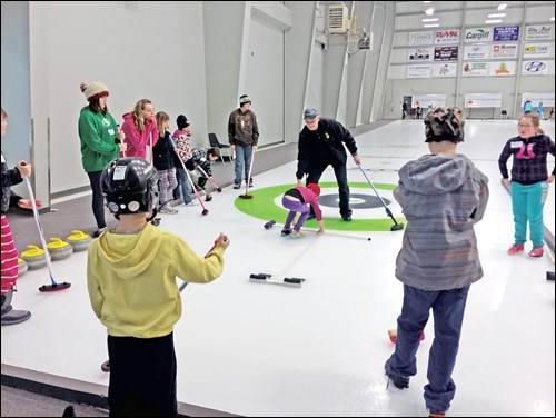 Volunteer coach Lorne Voinorosky instructs the 4-Hers on the ice.