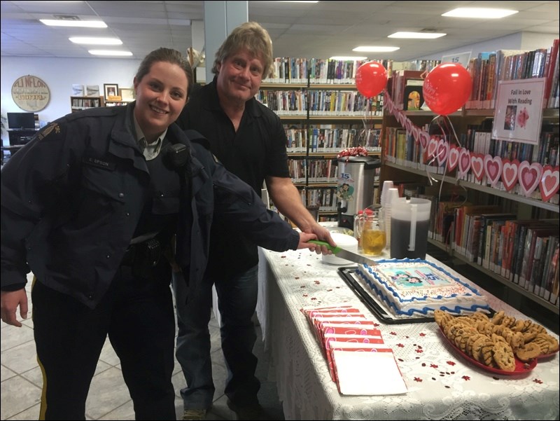 Cst. Kayla Upson of the Flin Flon RCMP and Mayor Cal Huntley cut the cake at Tuesday’s Family Literacy Day celebrations at the Flin Flon Public Library. The two also served as guest readers for the children attending the fun event.