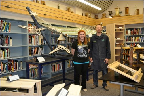 Savannah Martin and her industrial arts instructor Jeff Kardynal in the John Paul II Collegiate library where a variety of shop projects were on display. Savannah built a hammock stand.