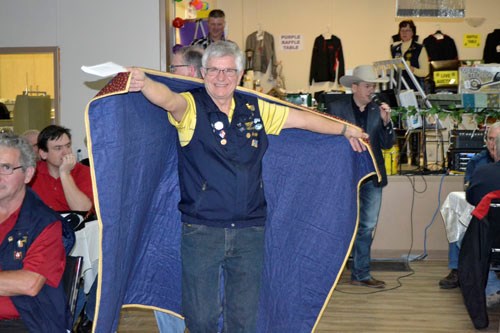 Lion and sale runner Ron Paul kept the auction action going as he displayed a quilt to potential buyers.