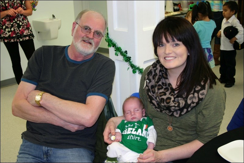 Little Nicholas Tost, sleeping in the arms of his mother, Karmalee Tost, wore his “My First Ireland Shirt” to the St. Patrick’s Day tea at St. Ann’s Roman Catholic Church on Saturday, Mar. 14. Nick Shaw, Karmalee’s father and grandfather to the five-and-a-half-week-old, came to Canada from Ireland.