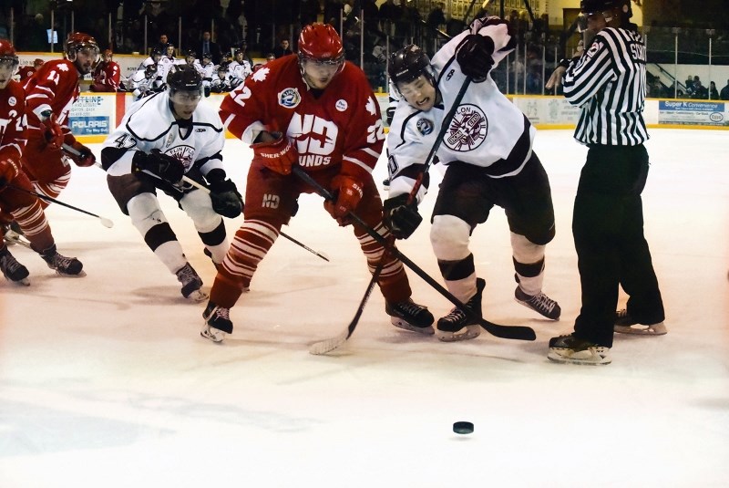 Bombers centre Alex Smith (right) attempts to beat Hounds centre Cory Anderson to the puck Tuesday at the Whitney Forum, with Flin Flon winger Jason Cohan looking on. The Bombers lost Tuesday but won Wednesday to even up their best-of-seven series 2-2 heading into Wilcox tonight.