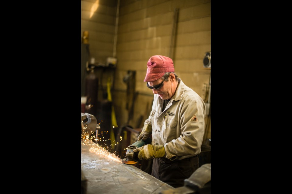 Welder Evan Reddick works on hard surfacing ripper shanks in the Jerry Mainil Ltd. welding shop.