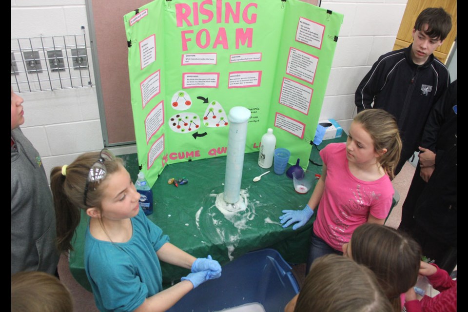 Gabrielle Stephany, left, and Taylor Dickie show off their rising foam experiment at the Sacred Heart School's science fair on April 1.