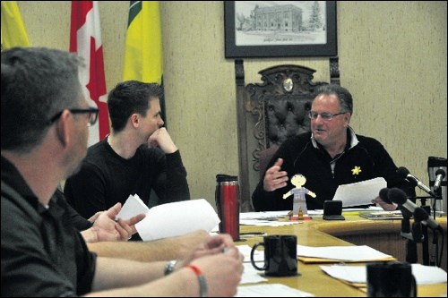 Flat Oscar (centre) has been to several sites in Battleford with assistant administrator Colin Olson (left) and was a visitor at last week's town council meeting, sitting near Mayor Derek Mahon (right).