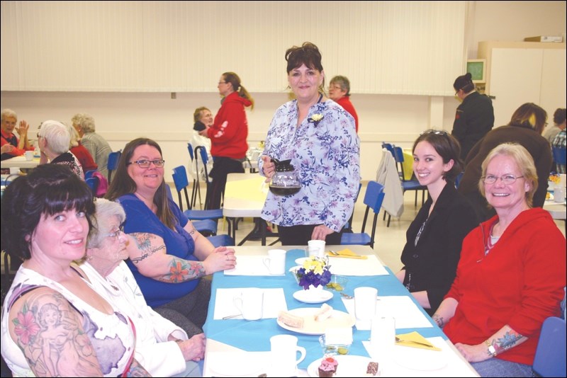 Generations of the McIntyre family came out for the tea. Shawna Dubreuil (left) and her sister, Dawn McIntyre, flank their grandmother, Jane McIntyre. Mom Jan McIntyre (right) sits with family friend Heather Richardson, while Legion Ladies Auxiliary member Heather Lehman is ready with the coffee.