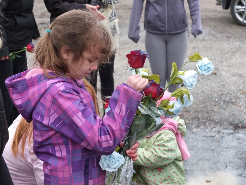 Jade Grant, 7, Raylene’s niece, helped hand out flowers to the mourners.
