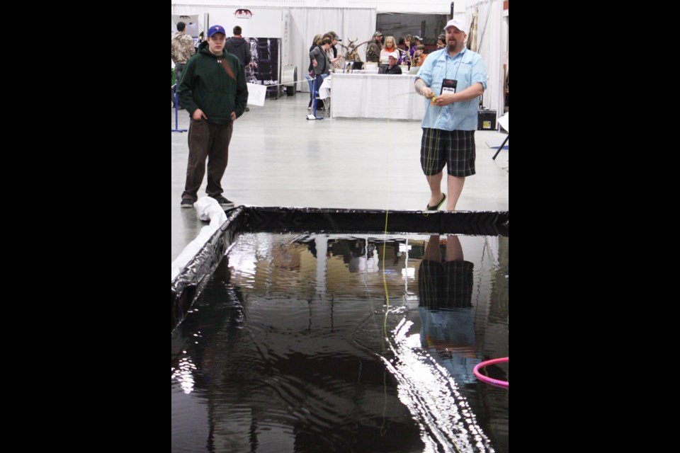 Patrick Thomson demonstrates fly fishing in the curling rink.