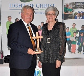 Adrienne Welter presents the Lumen Christi award to Ken Loehndorf. Photos by John Cairns