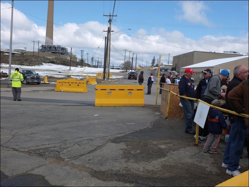 A Hudbay security worker (far left) stands guard near the picket line Sunday.