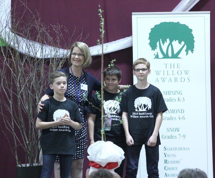 Leslie Gosselin, a representative of SaskEnergy, presented a willow tree to Assiniboia Park Elementary School. The school received the tree as a gesture of thanks upon completion of the 2015 Willow Awards Ceremony held at the school on May 14. In addition to the tree, the school received a collection of books written by the 2015 nominees for the 2016 Willow Awards. Students (l-r): Zander Muxlow, Caleb Gill and Dylan Warken.
