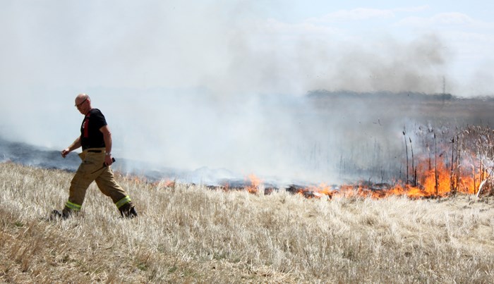 Captain Brian Belitsky of Yorkton Fire Protective Services surveys the edge of a fire that consumed the better part of a quarter section (160 acres) of crop stubble and cat tails just east of Yorkton on Hwy 10, May 20. A pickup truck being used to refuel tractors experienced a mechanical failure and caught fire. Recent dry weather and a substantial wind provided perfect conditions for the blaze to spread. Fearing the flames would jump the road, police closed the highway for approximately 45 minutes rerouting traffic onto the grids. Ultimately, the fire was contained by letting it burn toward a slough on the south and using deep tillage of the soil to prevent it from spreading north and east.