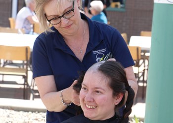 Brayden Ottenbreit’s Close Cuts for Cancer is in the community, both raising money for the local initiatives program and getting people ready for their main head shave event for cancer research. Pictured above, Helen Ferridge gets five years worth of hair shaved off by Leone Ottenbreit at the gourmet hot dog sale at Cornerstone Credit Union, with that hair donated to the Pantene Beautiful Lengths program, to make wigs for cancer patients. Ferridge, who also raised $2,050 for the cause, says that if her hair can improve the life of someone else, she will happily grow it. The main head shave event will be on May 30 at 10:00 a.m. at the Parkland Mall.