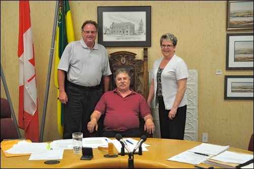 Last Meeting — Kevin Chaykowski, retiring superintendent of works and utilities for the Town of Battleford, got to sit in the historic chair of the council chamber at his last official meeting with town council Monday, pictured with Mayor Derek Mahon and Administrator Sheryl Ballendine. The mayor said it will be a new experience for Chaykowski to be able to walk away from the phone.