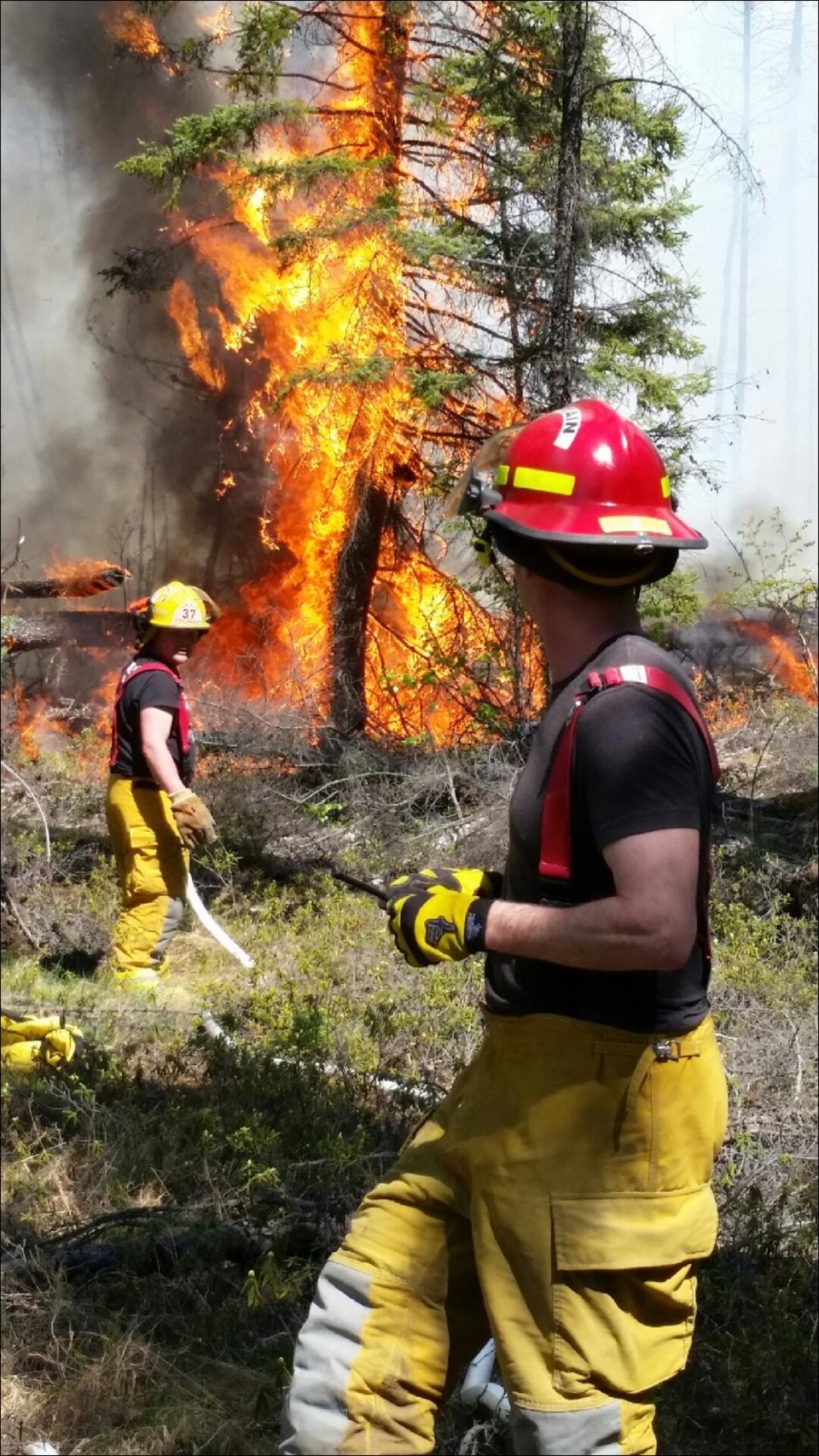 Firefighters Damien Dominey (back) and Darren Romo at the fire scene.