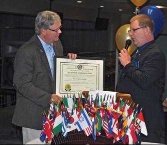 John Jangula presents the president’s pin and club charter to the new president of Battlefords Rotary Club, Bryan Nylander.
