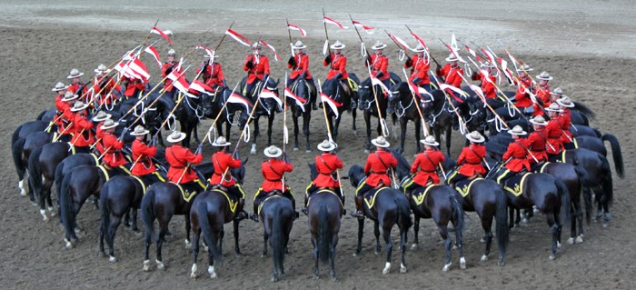 Above: The RCMP Musical Ride performs the iconic “Dome” during a performance Saturday afternoon at the Yorkton Exhibition. Below right: Constable Kyle Kifferling, from Southey, Saskatchewan, and his horse Anne pose with a young fan prior to the Saturday show.