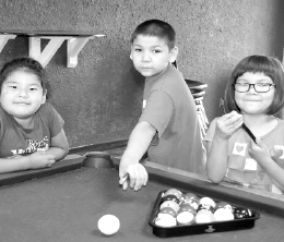 Photographed last week at the pool table located in the Little Heaven Youth Lounge at Keeseekoose First Nation, from left, were: Camille Keshane and Nico and Jane Kakakaway.
