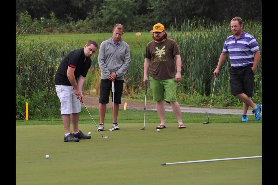 Golfers, from right, Chris Gould, Devon Choma and Carter Walliser watch Kyle Kallis make a putt on the 10th hole last Thursday at the 2015 Estevan Police Officers Memorial Open at TS&M Woodlawn Golf Club.