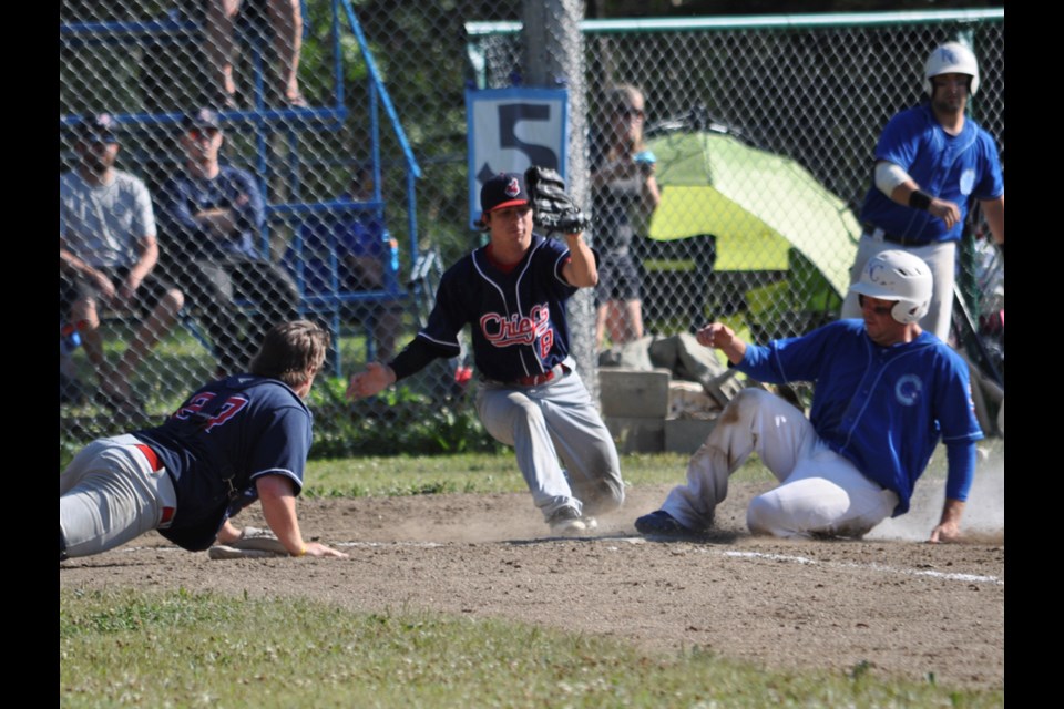 Cubs base runner Jason Shife beats Chiefs pitcher Bryce Burrett to the plate, while catcher Jordan Cooney looks on, to score Kenosee's second run in the top of the fifth inning of their 4-3 come-from-behind win over Oxbow in the first semifinal game of the 2015 Jack Harbourne Memorial Tournament last Sunday at Kenosee.