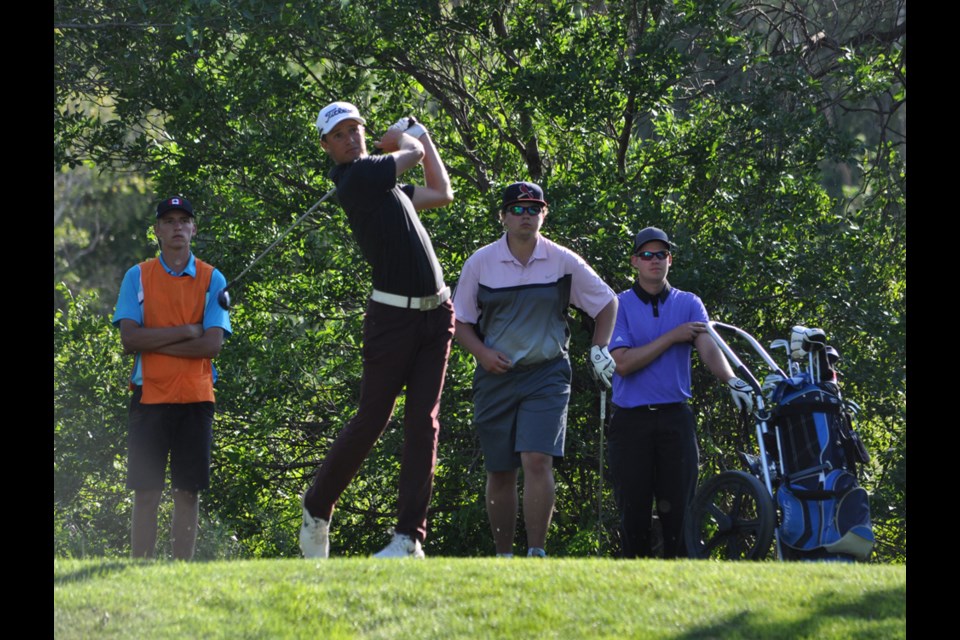Winnipeg's Charles Boyechko drives a ball from the 15th tee while final round teammates, from right, Jehremy Ryde and Mitchell Matichuk, with caddie Stephen Oleskiw, wait for their turn to tee off. Boyechko maintained his lead throughout the final round and finished the four-day tournament with a score of 2-over 290.