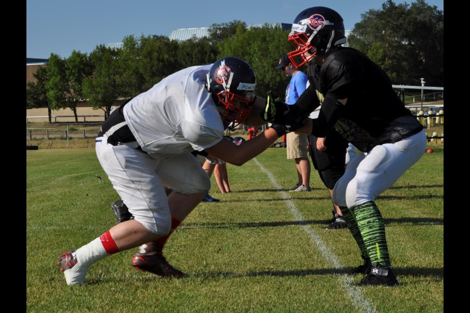 ECS Elecs football player Adan Peterson attempts to break past Carter Davenport during a lineman practice at football camp Monday at Estevan Comprehensive School.