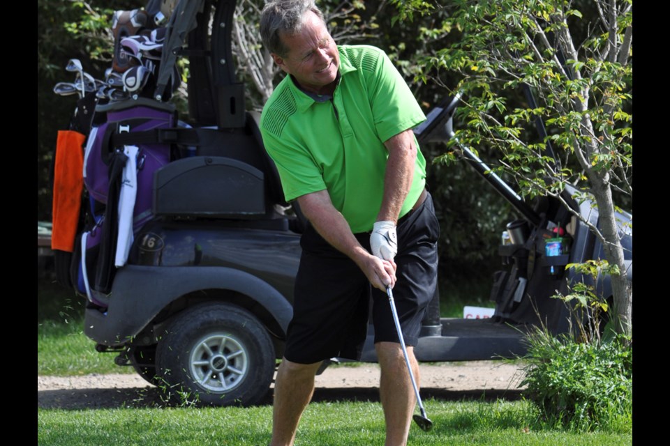 Vern Symons chips onto the fourth hole green during the Young Focus Charity Golf Tournament Friday at Hidden Valley Golf Club.