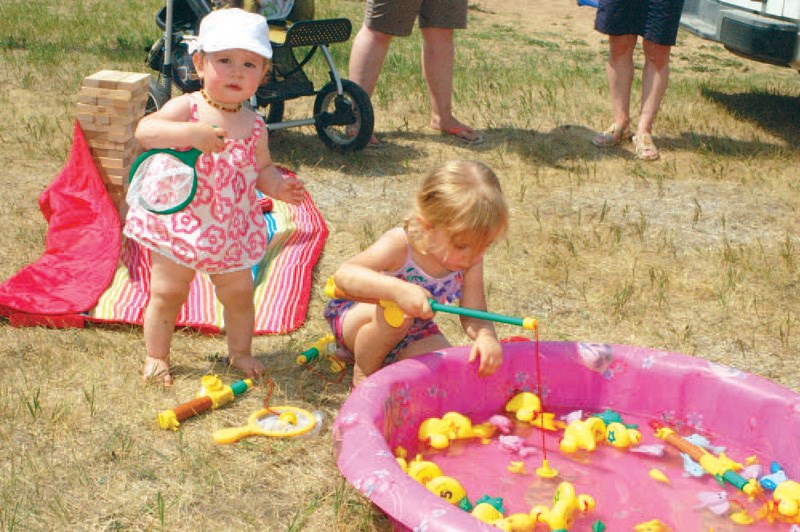 Having fun playing in the water and “ﬁshing for ducks” during the Western Weekend on July 11 were: Lindy (left) and Eva Romanchuk.