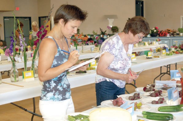 Angela Poirier, left, helped Karen Leis of Runnymede, the judge, record the results from the Provincial Horticultural Show held in Sturgis on August 13.