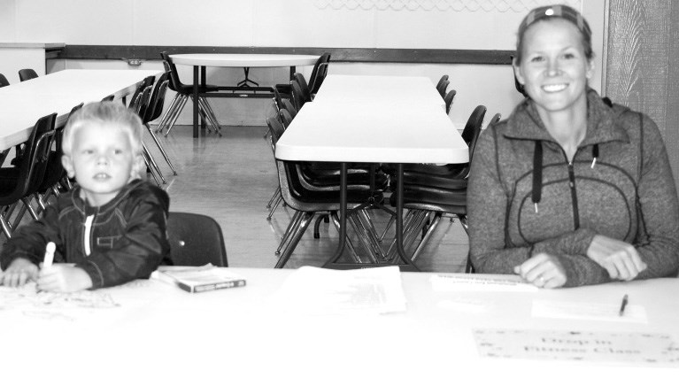 Lisa Moekerk had help from her son Carter in manning her ﬁtness class table at the Town of Preeceville registration and information evening on September 8.