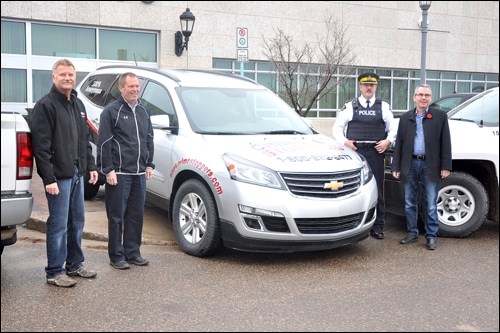 Sgt. Rob Cozine, Herb Sutton, Insp. John Sutherland and Mayor Ian Hamilton were at Battlefords RCMP detachment Tuesday, promoting the Crime Stoppers bumper sticker campaign on City vehicles in North Battleford.  Photos by John Cairns